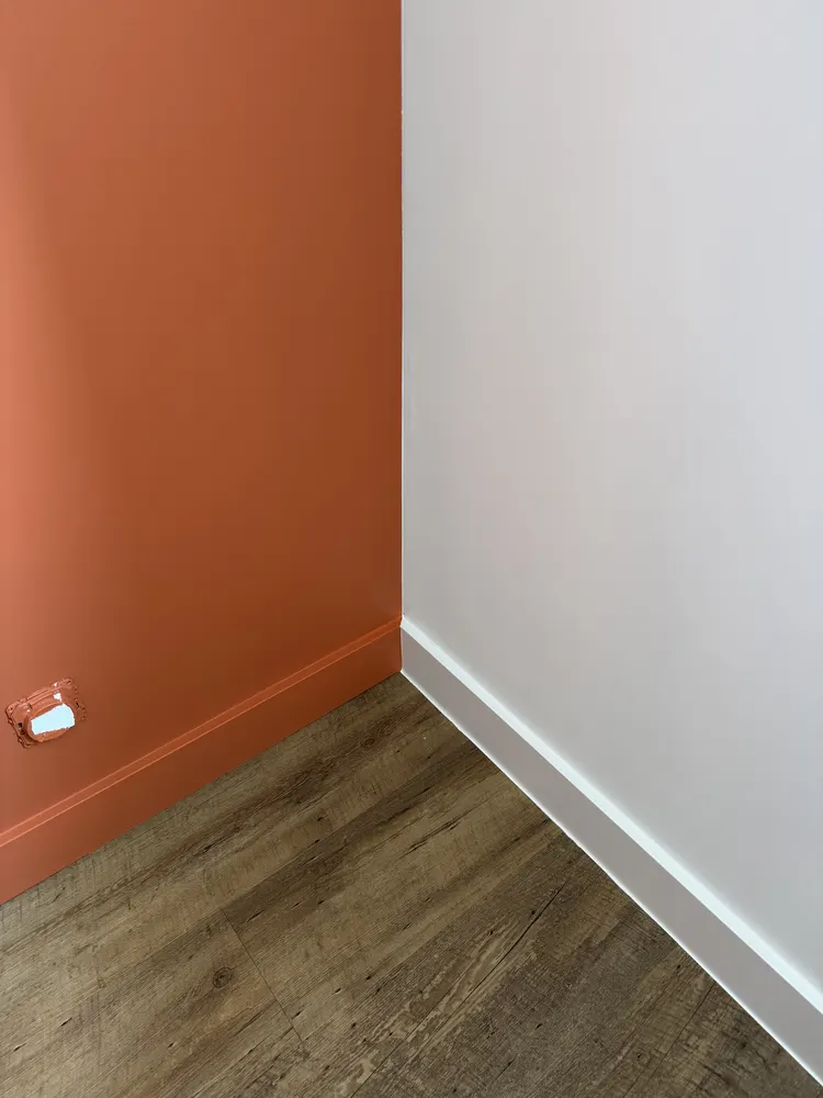 Chambre en sous-sol avec mur terracotta après aménagement — La Tessoualle (49)
